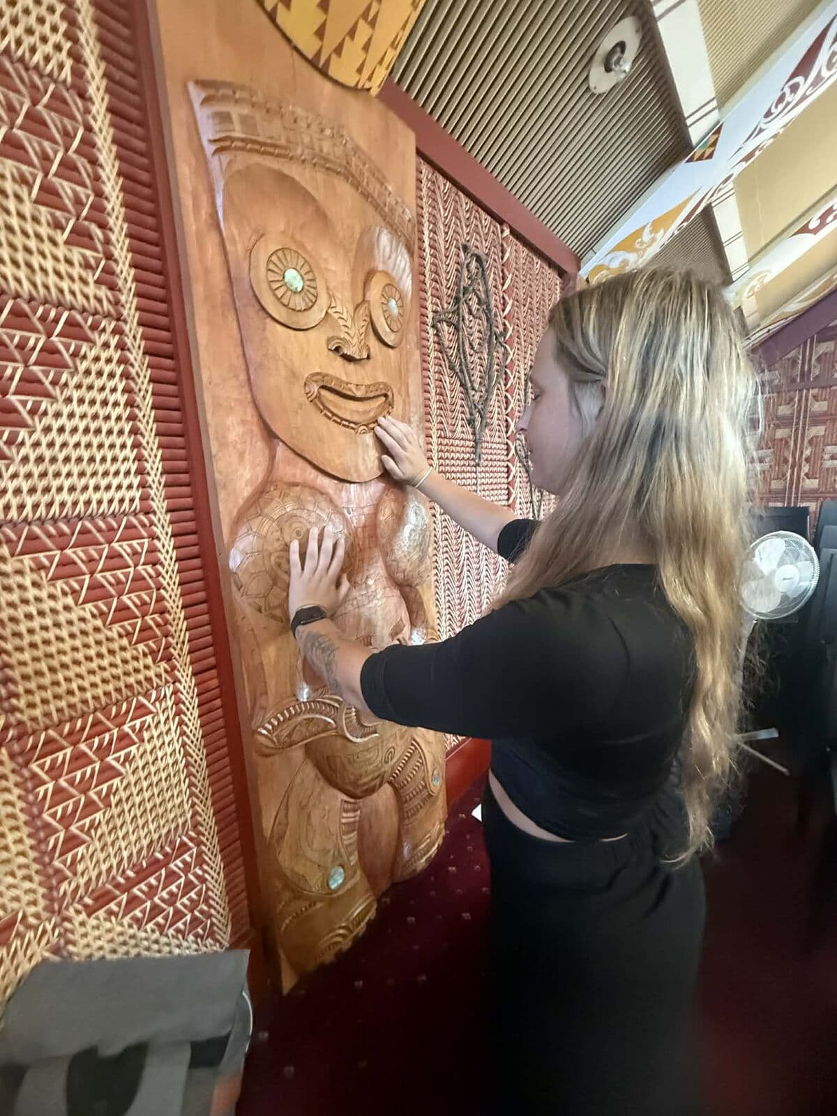 A woman exploring carved figures through touch